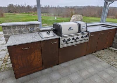 Eine Outdoor-Küche mit einer stählernen Überdachung. Im Hintergrund ein Golfplatz.