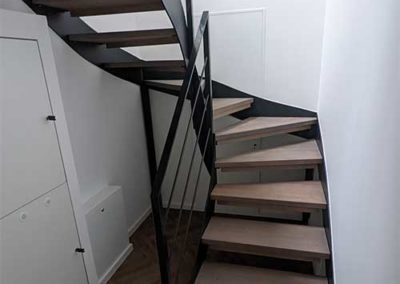 Eine Treppe mit schwarzer, stählerner Halterung und hölzernen Stufen.
